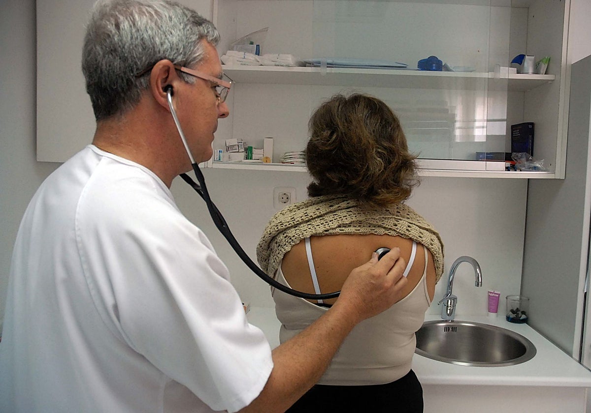 Un médico ausculta a una paciente en un centro de salud.