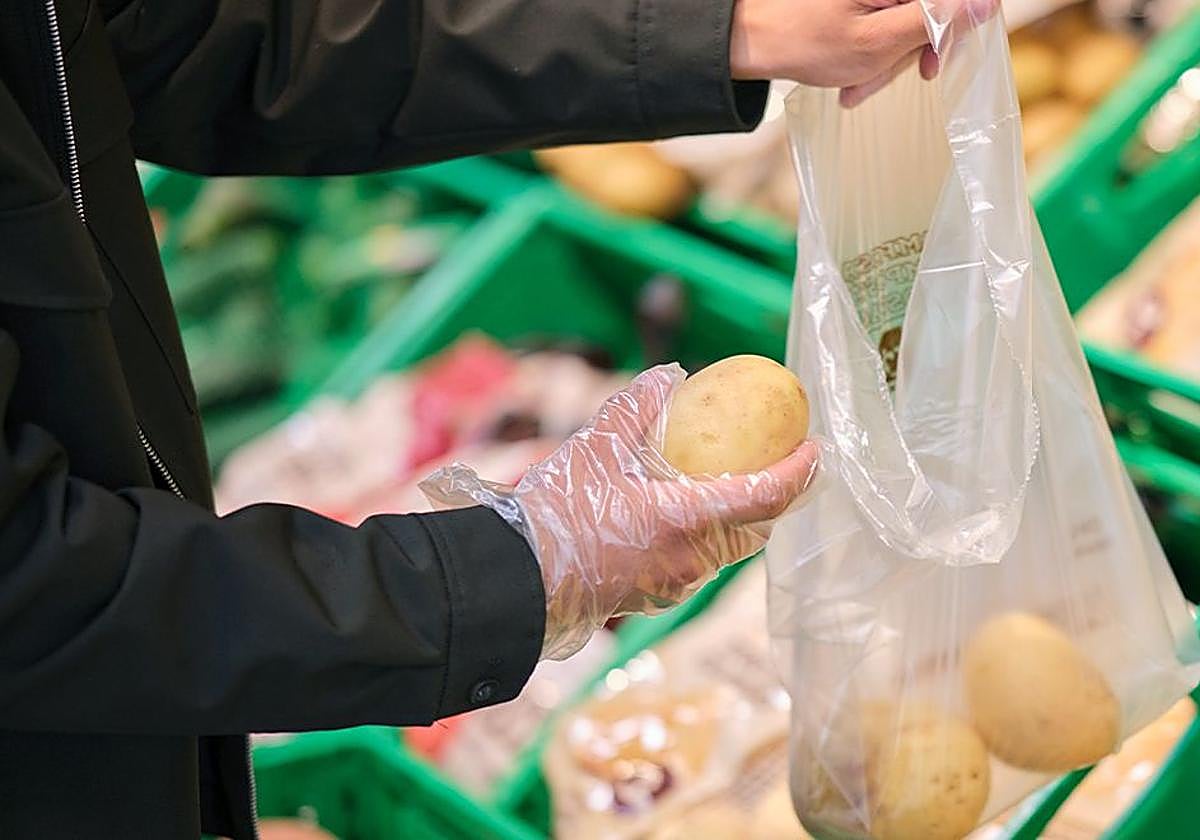 Una persona compra patatas en Mercadona.