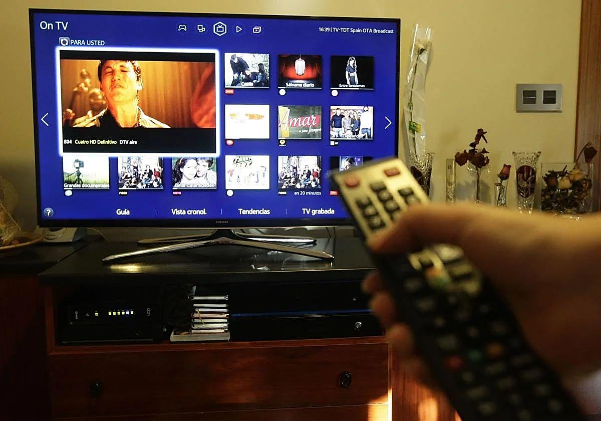 Una persona ordena los canales de su televisor con un mando a distancia.