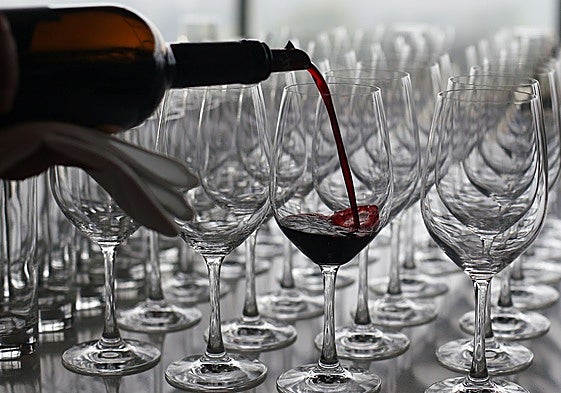 Un camarero sirve una copa de vino.