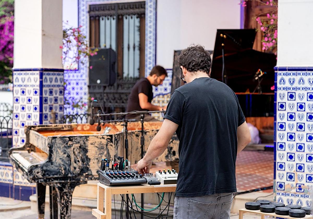 Los artistas en pleno trabajo, con el piano cubierto de barro.