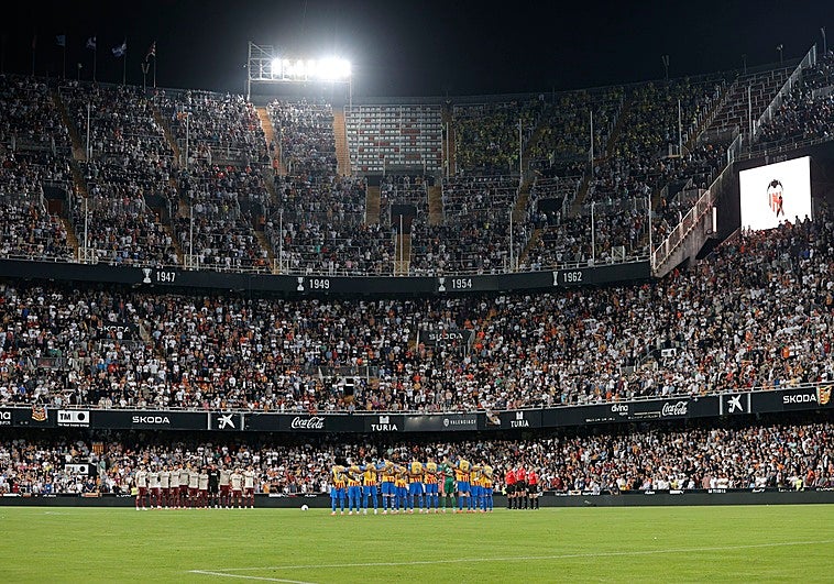 Los dos equipos, el trío arbitral, y todo el estadio puesto en pie durante el minuto de silencio en Mestalla en memoria de las víctimas de la dana.