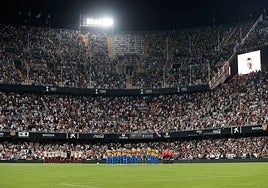 Los dos equipos, el trío arbitral, y todo el estadio puesto en pie durante el minuto de silencio en Mestalla en memoria de las víctimas de la dana.