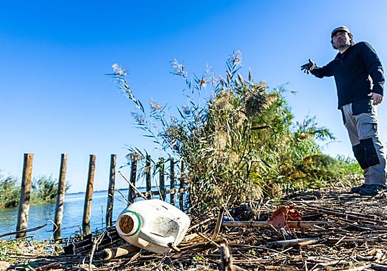 El biólogo Javier Jiménez Romo señala un montón de residuos en una mota de la Albufera.