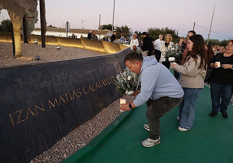 El padre de Izan y Rubén coloca una vela y flores en el monumento en recuerdo de los fallecidos en Torrent.