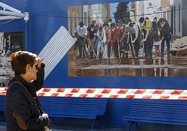 Una vecina observa uno de los murales en la plaza del Ayuntamiento de Benetússer.