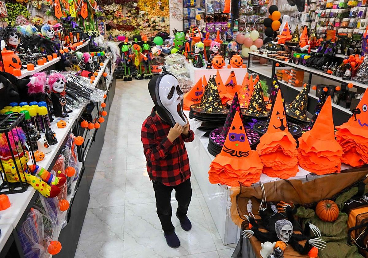 Un niño se prueba una máscara de Halloween.