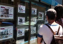 Ciudadanos miran anuncios de alquiler en una inmobiliaria, imagen de archivo.