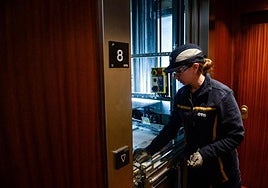 Una mujer revisa un ascensor.