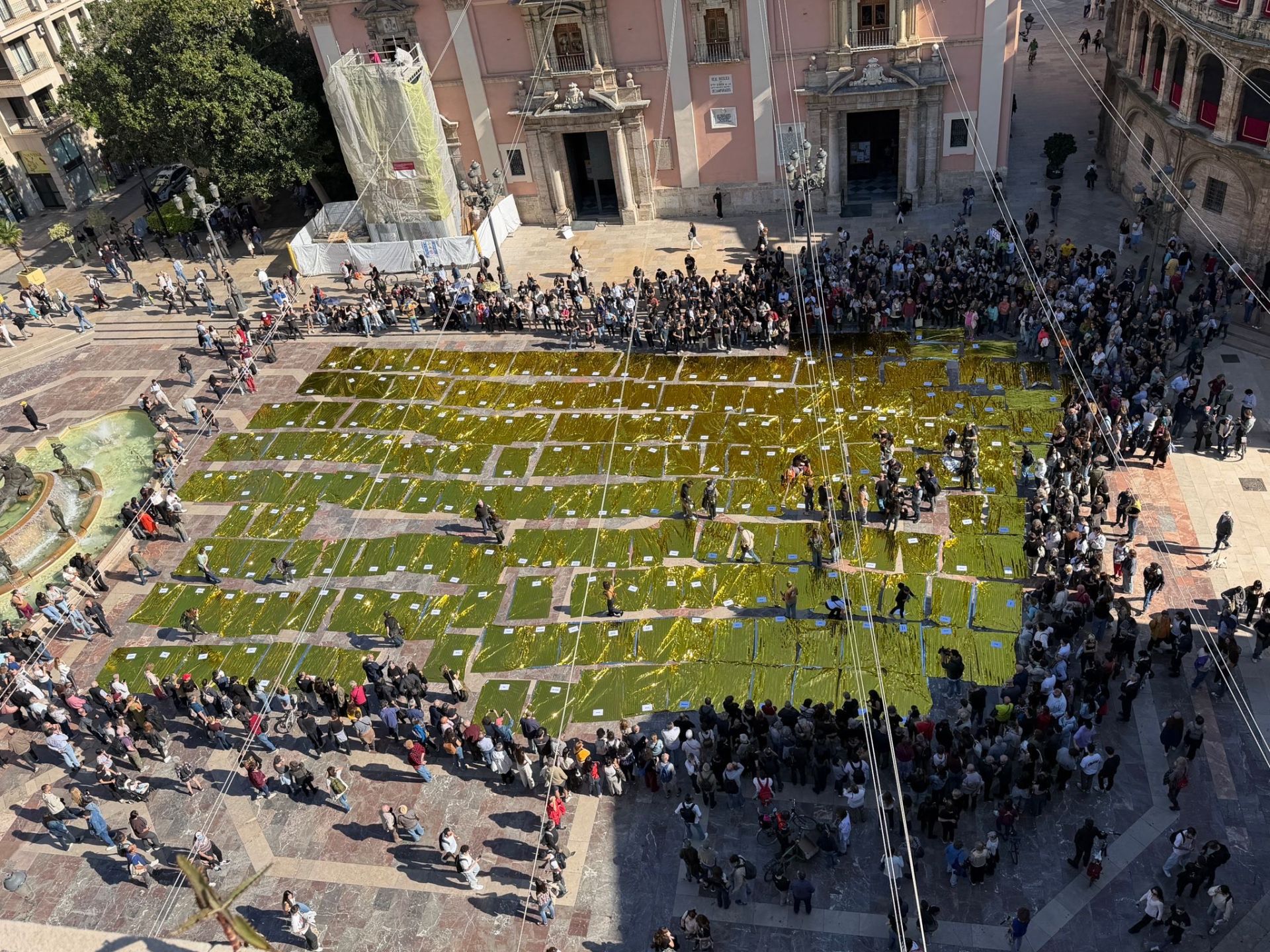 Despliegue de 229 mantas térmicas en el suelo de la plaza de la Virgen para recordar a los fallecidos.