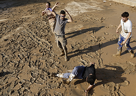 Unos jóvenes juegan en el barro en Alfafar días después de la dana.