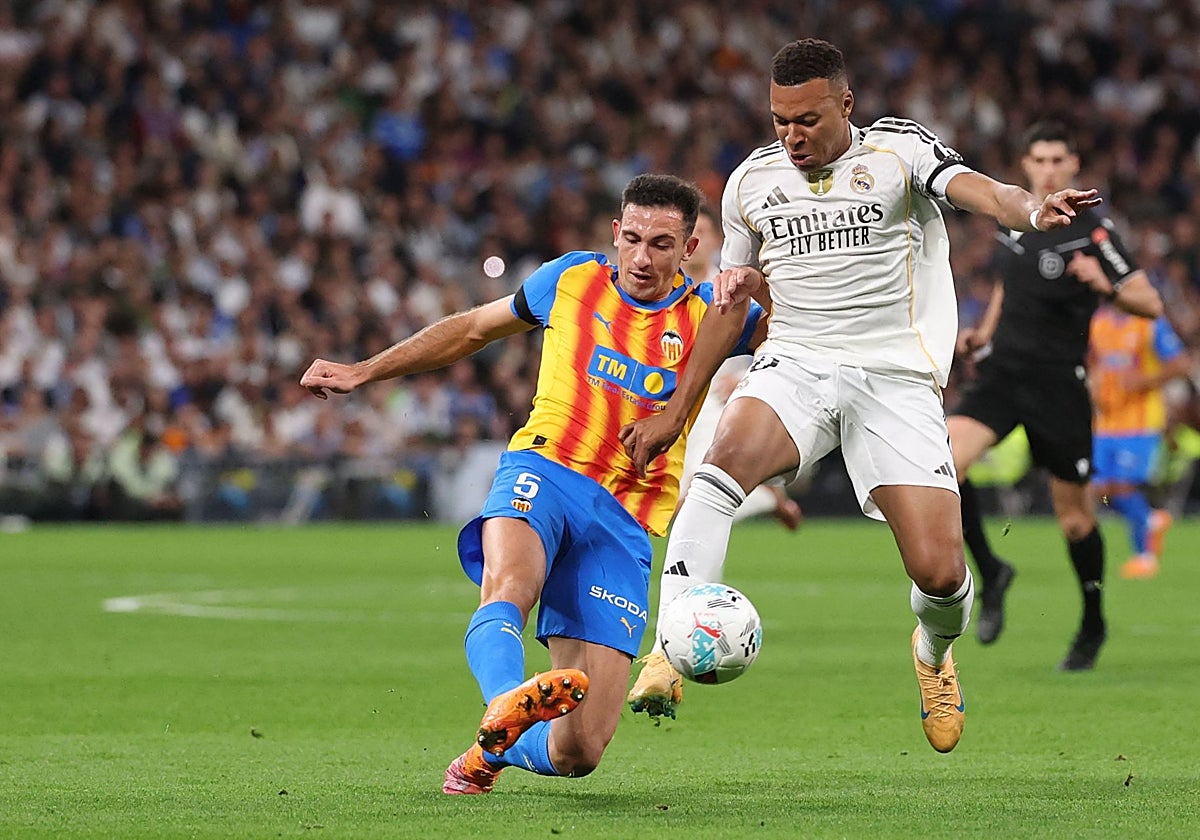 César Tárrega intenta quitarle el esférico a Mbappe.