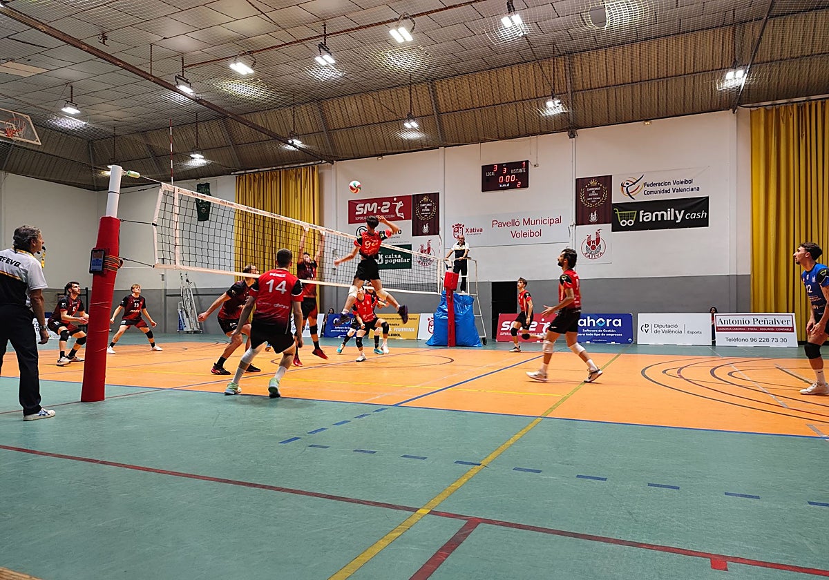 Un jugador salta para rematar en la red durante el encuentro