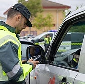 Un agente de Tráfico de la Guardia Civil comprueba la documentación de un conductor.