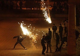 Gente lanzando petardos de gran calibre, en el Jardín del Turia de Valencia.