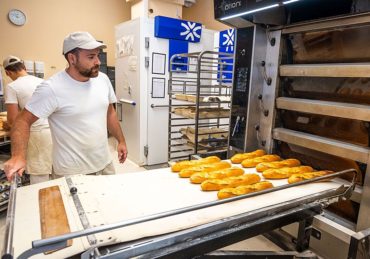Un trabajador del obrador Aspai, horneando barras de pan.