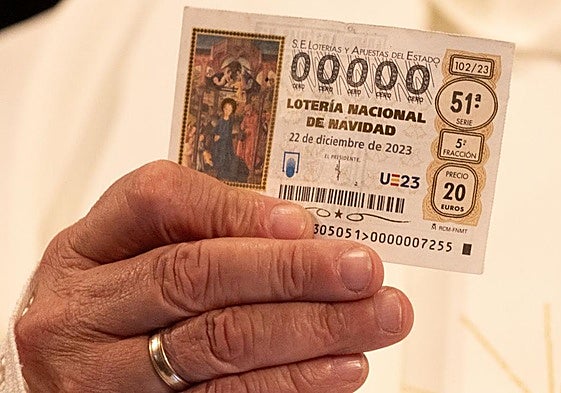 Una persona sujeta un décimo de la Lotería de Navidad.