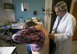 Un médico de familia ausculta a un paciente en el centro de salud.