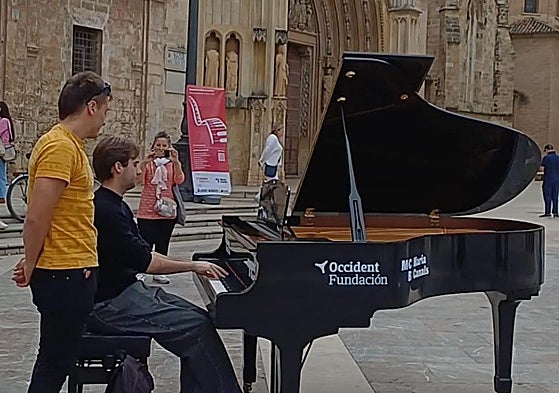 Alejandro, un pianista valenciano, interpreta una pieza en la plaza de la Virgen.