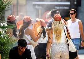 Turistas en la plaza de la Reina durante una ola de calor del pasado verano.