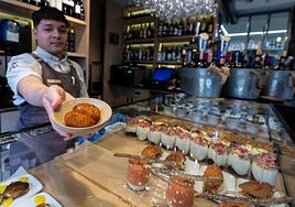 Un cocinero muestra las croquetas que sirve en su restaurante.