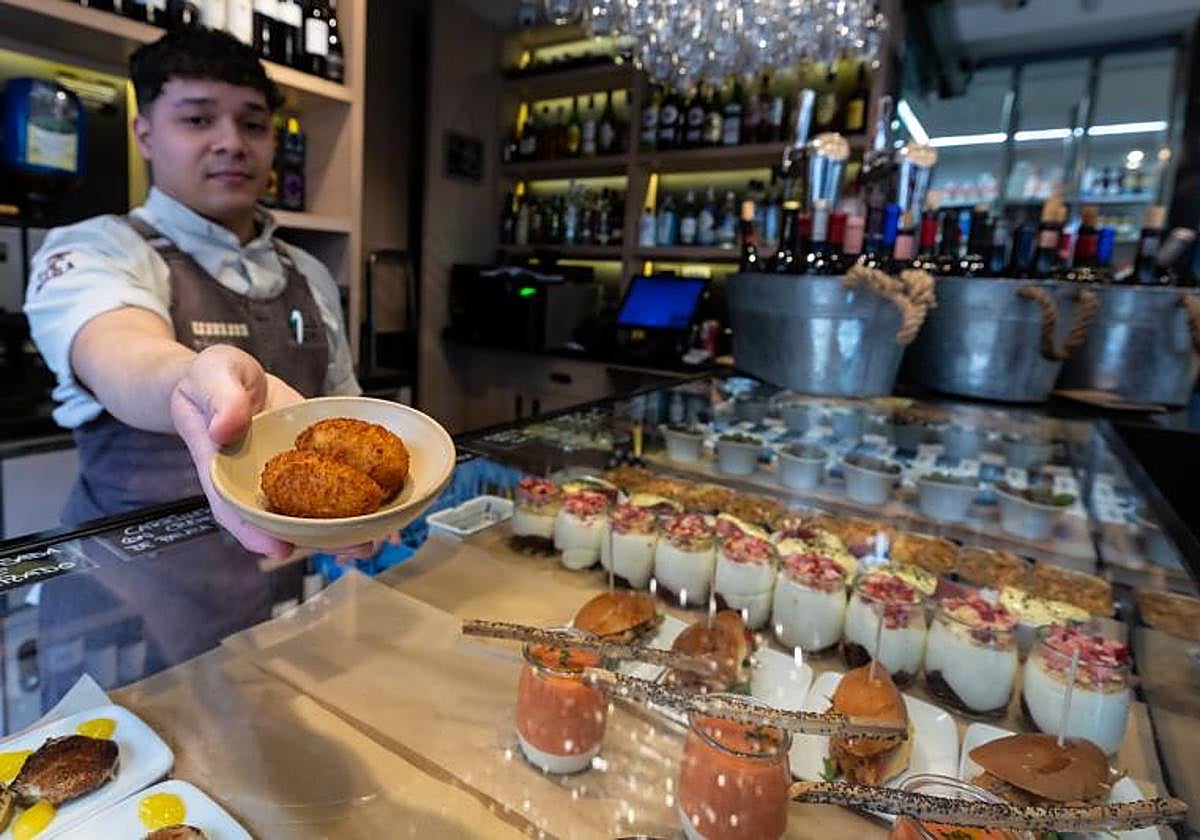 Un cocinero muestra las croquetas que sirve en su restaurante.