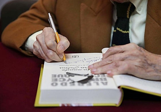 Un escritor firma un libro en una imagen de archivo.