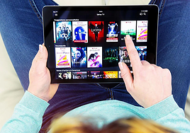 Una mujer utiliza Netflix en su tablet.