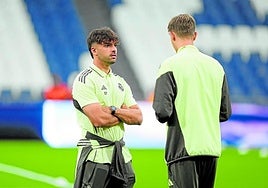 Asencio charla con Huijsen antes de un partido del Real Madrid.