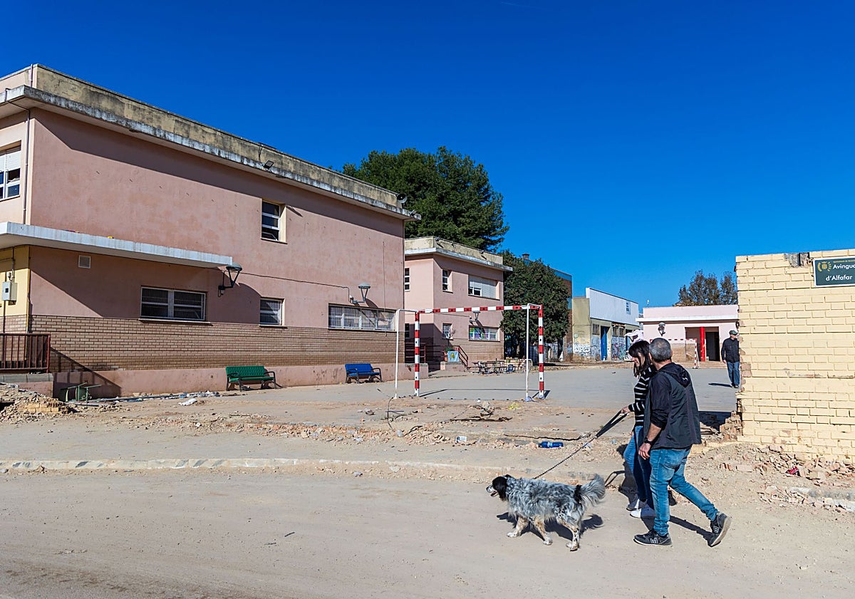 Imagen principal - Arriba, el colegio con el muro derruido, a mediados de noviembre de 2024. Abajo, la zona de Benetússer donde se ubica, el 30 de octubre. La fachada del centro se observa en el fondo de la imagen. La última foto es una captura de un vídeo que muestra cómo quedó el exterior de las instalaciones provisionales. 