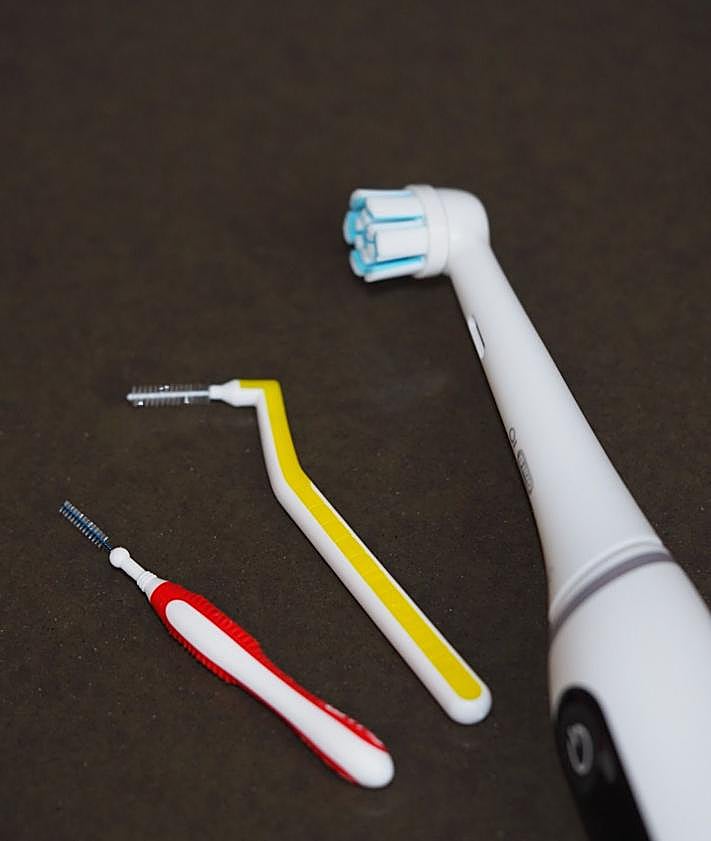 Imagen secundaria 2 - Cepillos manuales y enjuagues bucales en la Clínica Perios Salanova, detalle de los tres tipos de hilo dental y detalle de cepillo eléctrico y cepillos interdentales