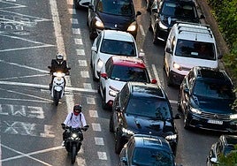 Motocicletas adelantan a una caravana de coches por una de las grandes vías de Valencia.