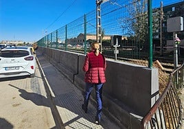 Una viandante pasa junto a la verja colocada en las vías en Alfafar.
