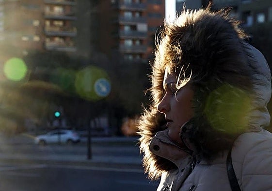 Una mujer camina abrigada.