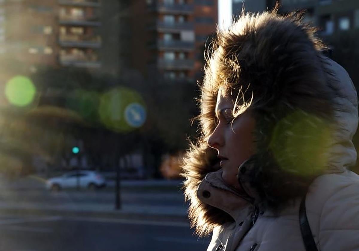 Una mujer camina abrigada.