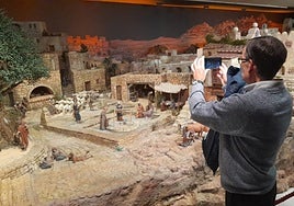 Un hombre fotografía el Belén expuesto en la Fundación Bancaja.