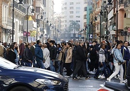 Ríos de personas transitan por la calle Colón, este sábado por la mañana, en busca de compras con rebaja.