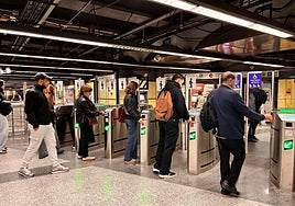 Viajeros validando su billete de metro en la estación de Colón en Valencia.