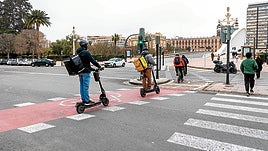Varios usuarios de un carril bici en el cruce de la Alameda con el puente de la Exposición.
