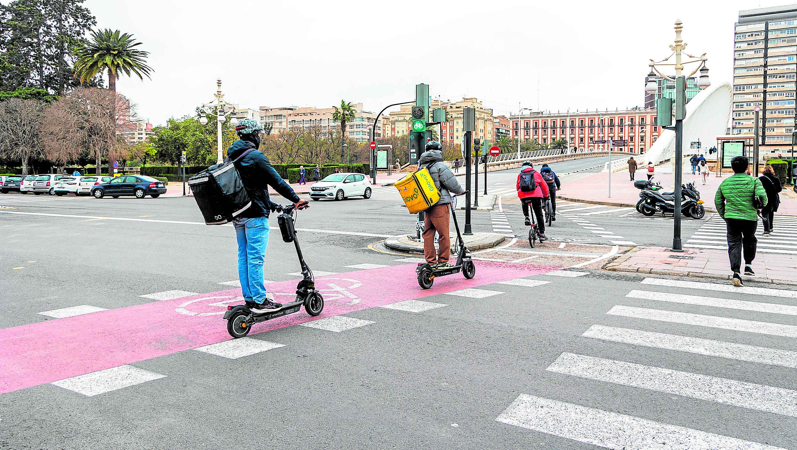 Varios usuarios de un carril bici en el cruce de la Alameda con el puente de la Exposición.