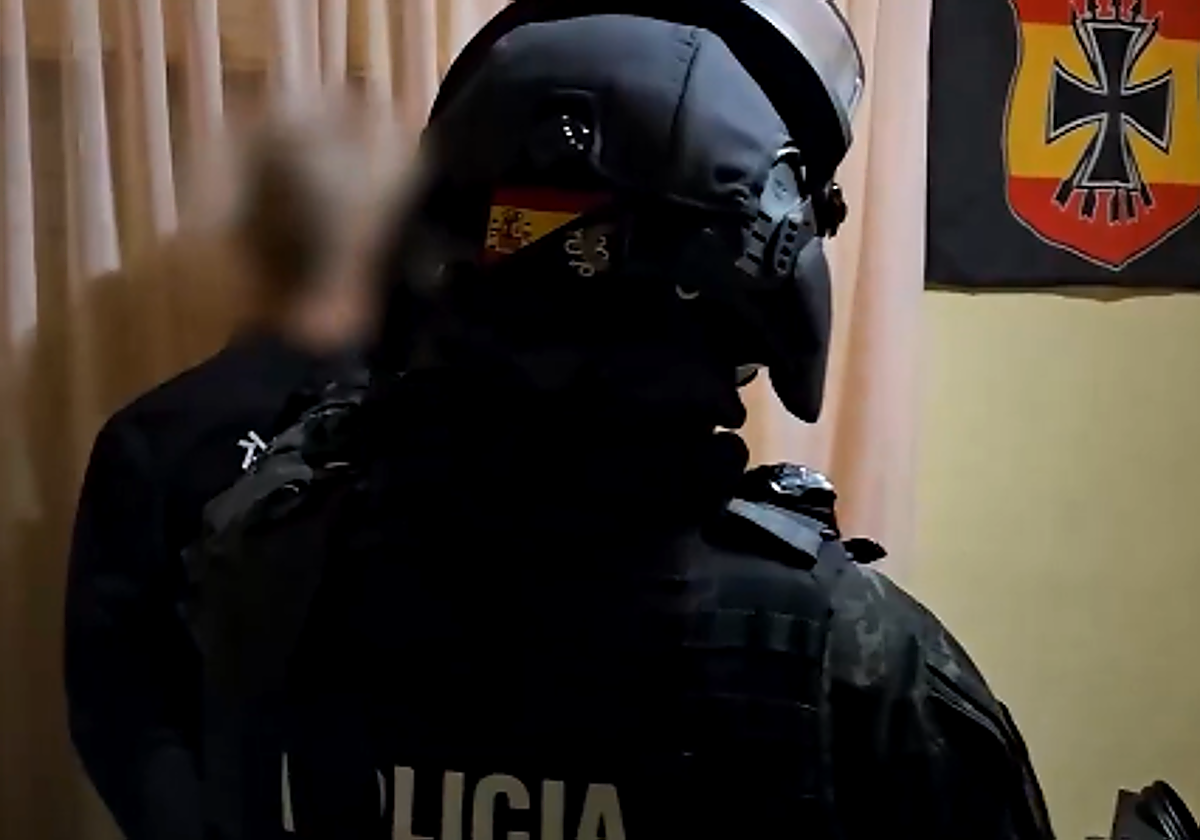 Un policía junto a uno de los detenidos en la operación.