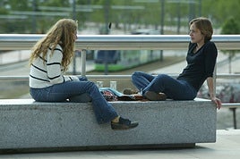 Dos jóvenes conversan en un parque.