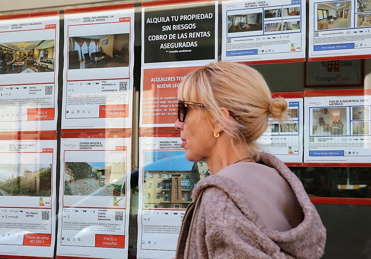 Una mujer pasa frente a una inmobiliaria con viviendas en alquiler.