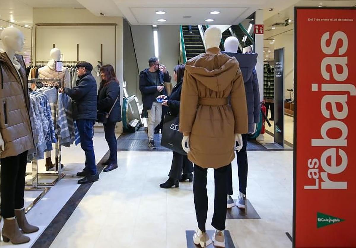 Varias personas buscan prendas con descuentos en El Corte Inglés.