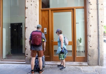 Dos turistas junto a un apartamento .