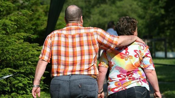 Una pareja pasea por un parque. 