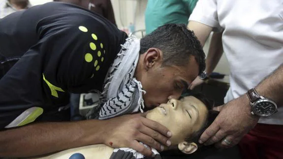 Un familiar besa el cadáver del adolescente fallecido. 