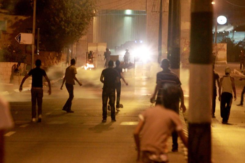 Manifestantes palestinos lanzan piedras hacia una torre de observación militar israelí