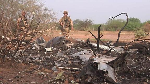 Dos soldados inspeccionan la zona donde fueron encontrados los restos del avión.