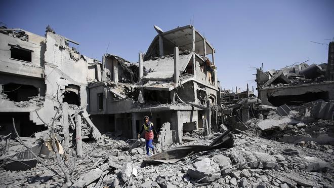 Una niña camina en un edificio destrozado 